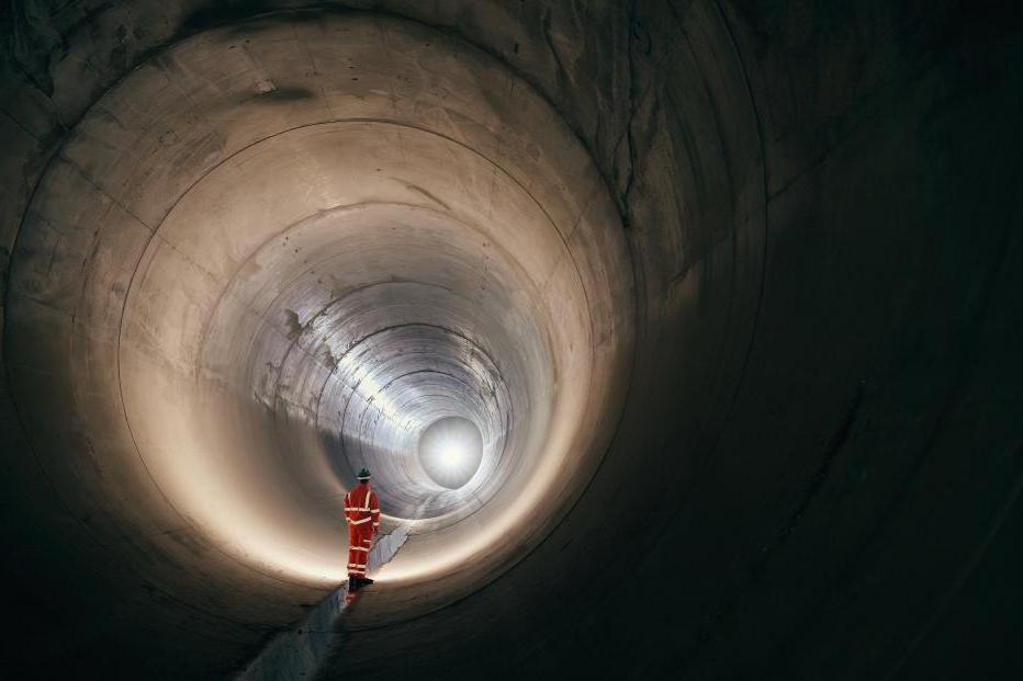 Worker standing in a sewer tunnel before operation.